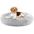 Beagle dog resting in a round fluffy grey plush cat bed