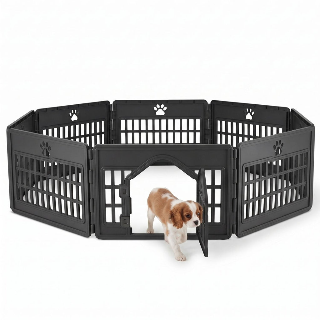 Black 6-panel modular plastic dog playpen with paw print cutouts and arched locking door; Cavalier King Charles Spaniel puppy walking out of the portable pet fence