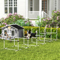 Dog running through white agility jump bars in front of a house
