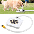 Golden retriever stepping on a white paw-print pedal water fountain with water spraying, plus product view of the pedal fountain with hose