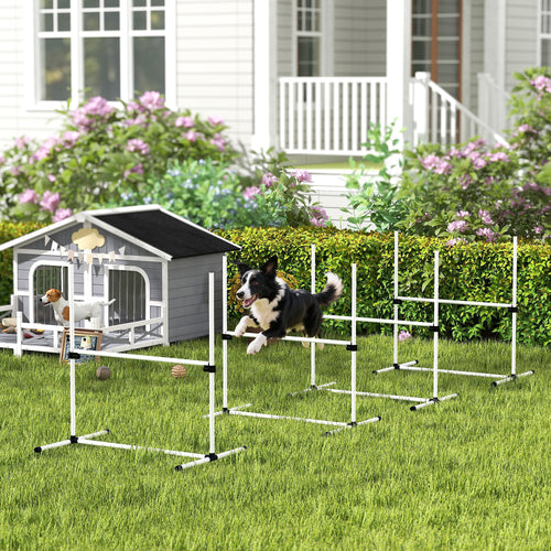 Border collie jumping through white agility jump bars on a lawn in front of a house