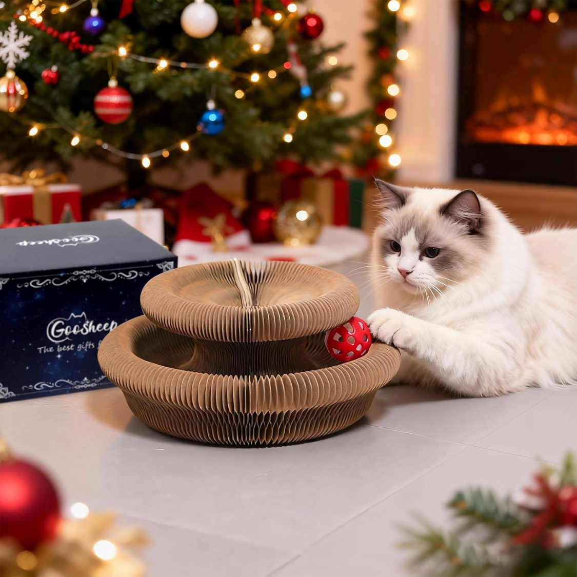 Fluffy cat playing with Kitty Kurlz accordion scratcher – red ball in track, Christmas tree and fireplace background