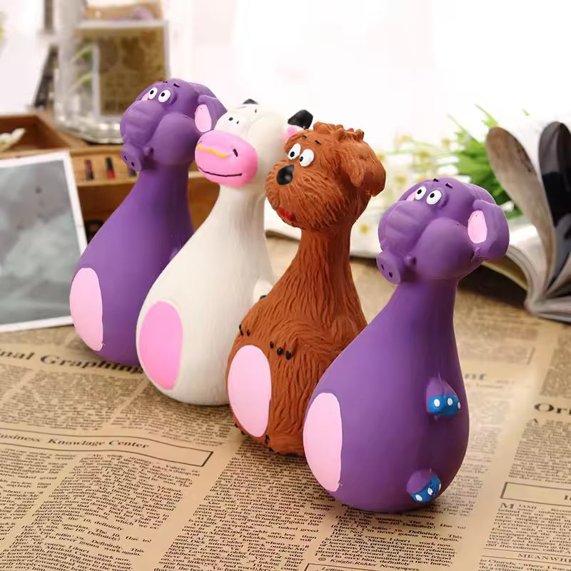 Four latex animal squeaky dog toys (two purple elephants, white cow, brown dog) standing on newspaper, showing pink bellies.
