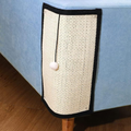 Natural sisal cat scratch pad on blue sofa corner – furniture protector with pom-pom toy