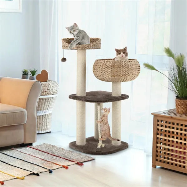 Water hyacinth cat tree in a living room with three cats on woven perches and scratching posts
