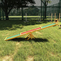 Wooden dog agility seesaw in a grassy yard