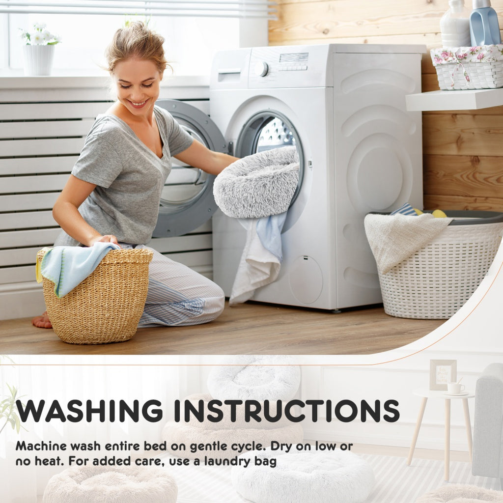 Person placing the washable fluffy cat bed into a washing machine