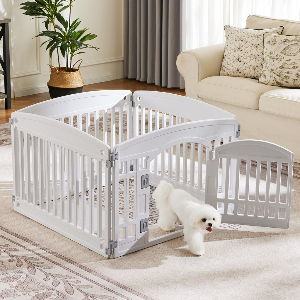White plastic dog playpen set up in a living room; small white fluffy dog walking out through the gate door of the indoor pet fence
