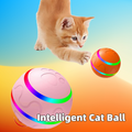 Orange kitten playing with pink and orange intelligent self-rotating cat balls with colorful LED light strips and paw print texture.
