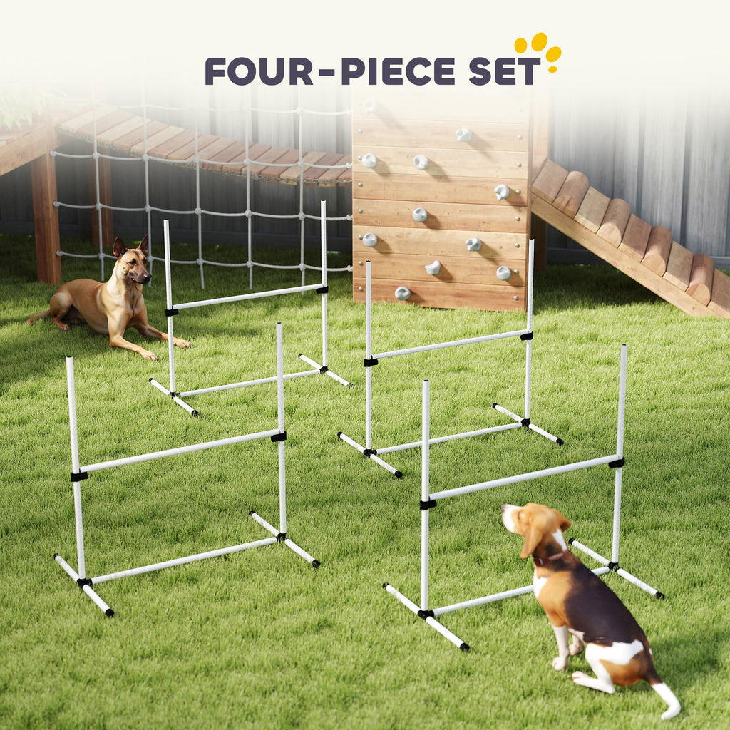 Four-piece white agility jump bar set on grass with two dogs and a wooden climbing wall